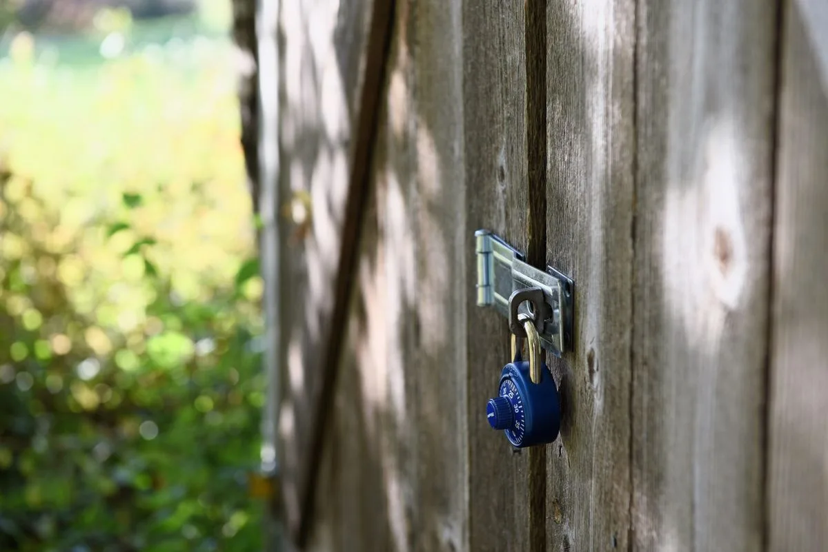 Combination padlock attached to a gate latch