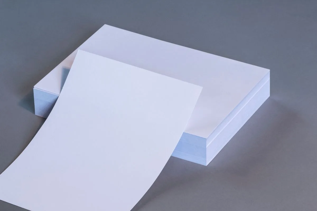 Stack of white paper reams on a neutral background